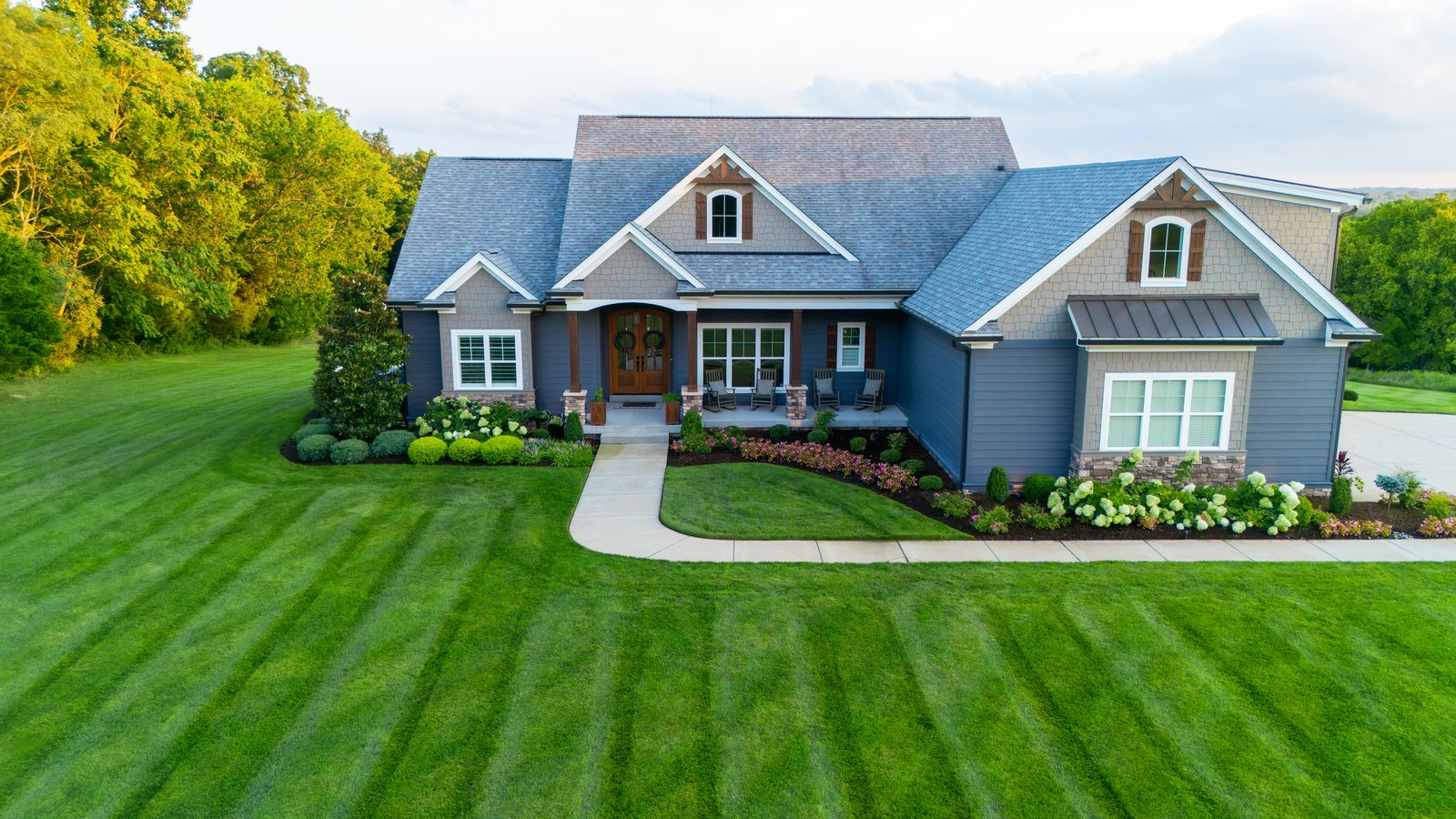 Blue Craftsman &mdash; front elevation with striped lawn.